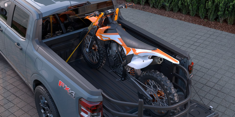2026 Ford Maverick FX4 shown hauling dirt bike using FLEXBED™ system in West Virginia — compact truck versatility for adventure seekers